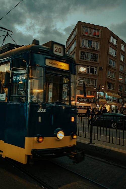 Yellow and Black Tram on Road during Night Time
