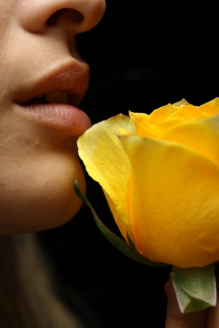 Selective Focus Photography Of Woman Smelling Yellow Rose Flower