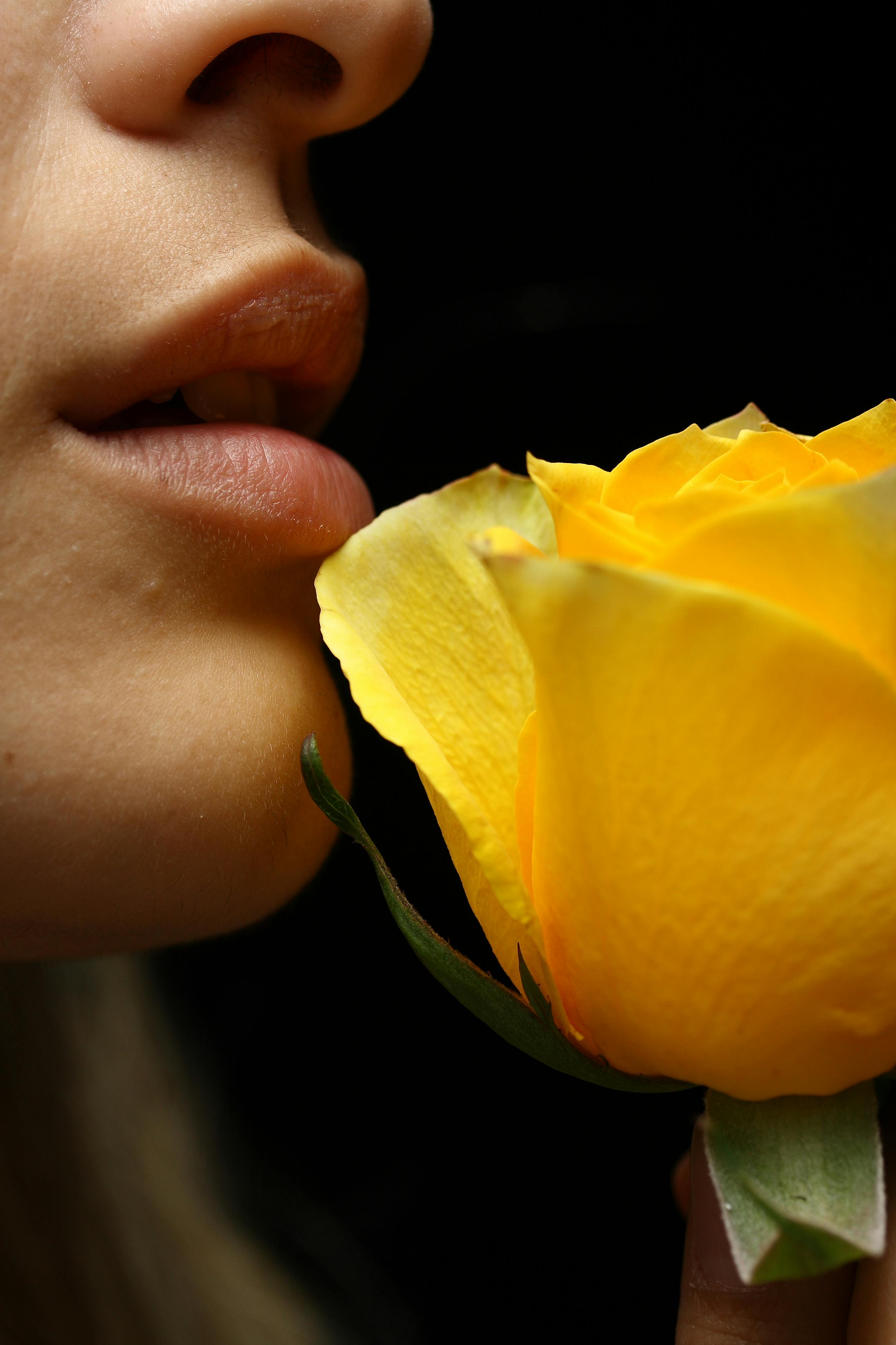 Selective Focus Photography of Woman Smelling Yellow Rose Flower · Free