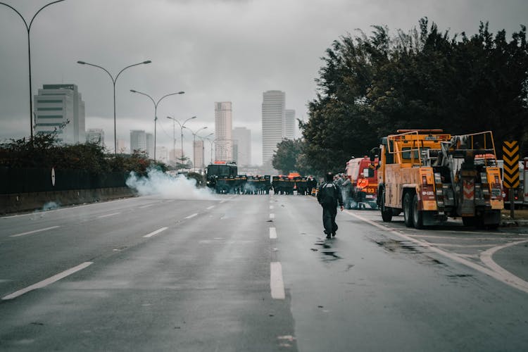 Person Walking Towards Police In Riot Gear