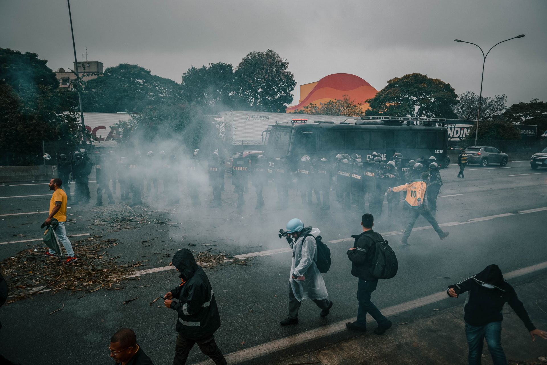 Bulutlu havada bir protesto sokağında kalabalık silüetleri