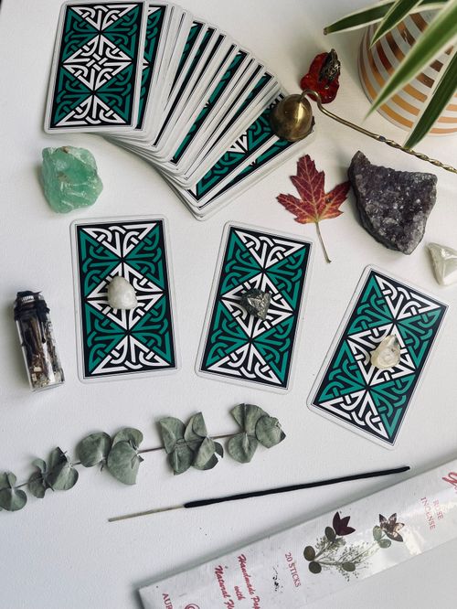 Free A flat lay of tarot cards with crystals, leaves, and incense, creating a mystical ambiance. Stock Photo