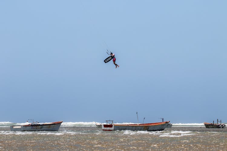 A Person Parasailing Under Blue Sky