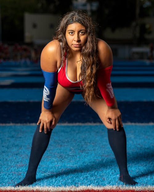 Woman in Red Sports Bra and Blue Leggings