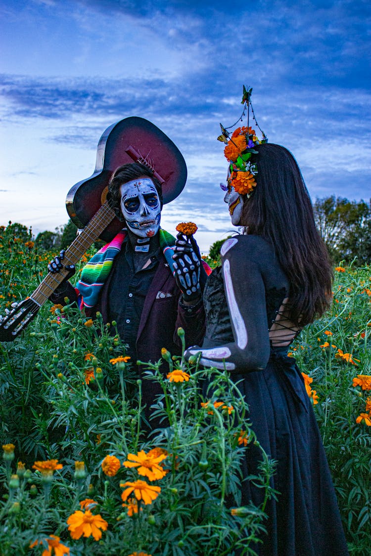 A Couple With Face Paint Standing In The Garden