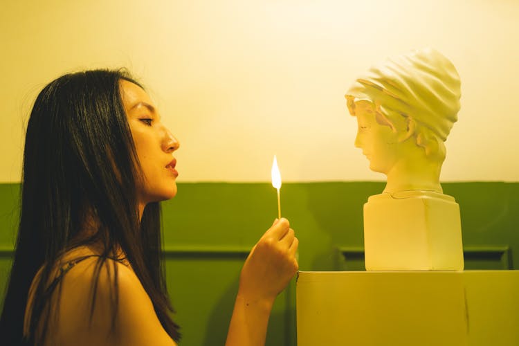 A Woman Holding A Lighted Match