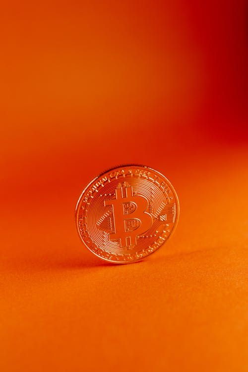 Close Up Photo of Bitcoin on Orange Background