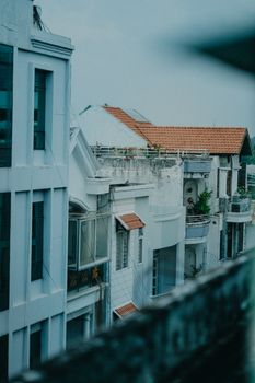 Modern urban residential buildings with rooftop gardens and terraces at daytime.