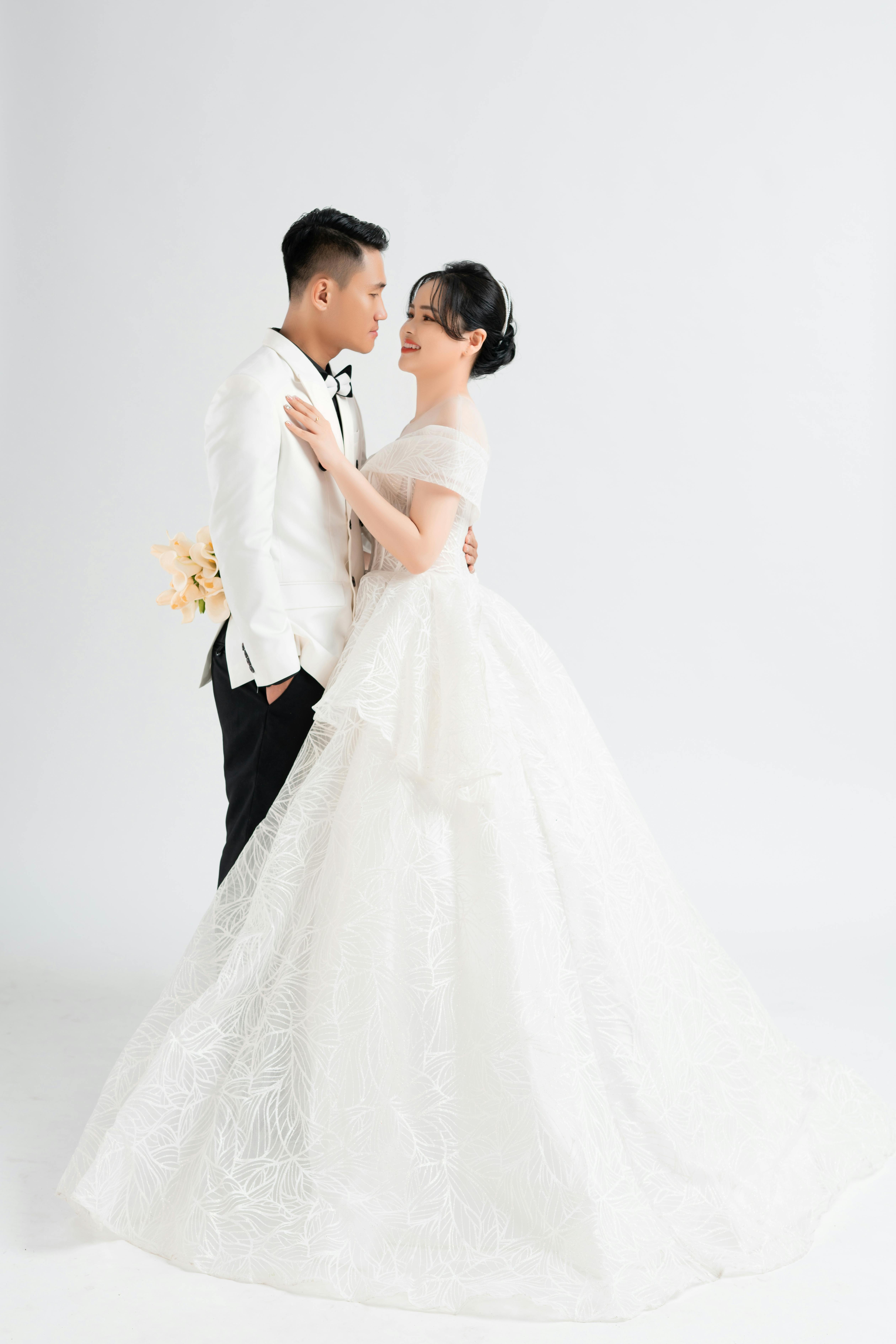 Stylish Asian couple in formal wedding attire during intimate studio photo shoot.