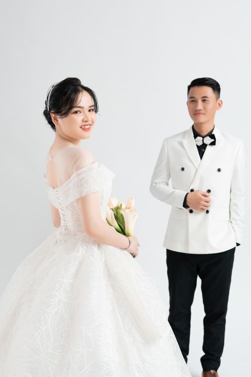 Free A stylish couple in wedding attire posing indoors for a pre-wedding photo shoot. Stock Photo
