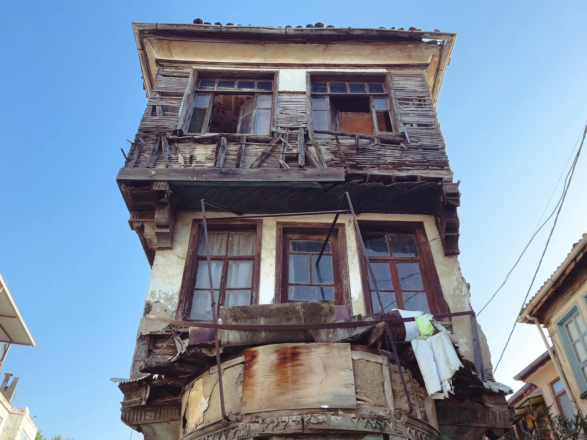 A derelict, dilapidated facade of a historical building under a clear blue sky.