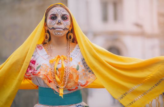 Woman in colorful Day of the Dead attire with artistic makeup in Mexico City