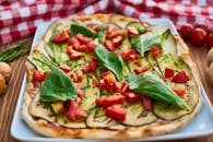 特写镜头里，一块充满活力的意大利披萨上撒着新鲜的茄子、罗勒和西红柿