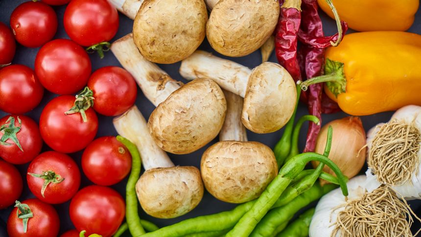 Grocery cart split between vibrant fresh vegetables and processed 'fake healthy' packaged foods