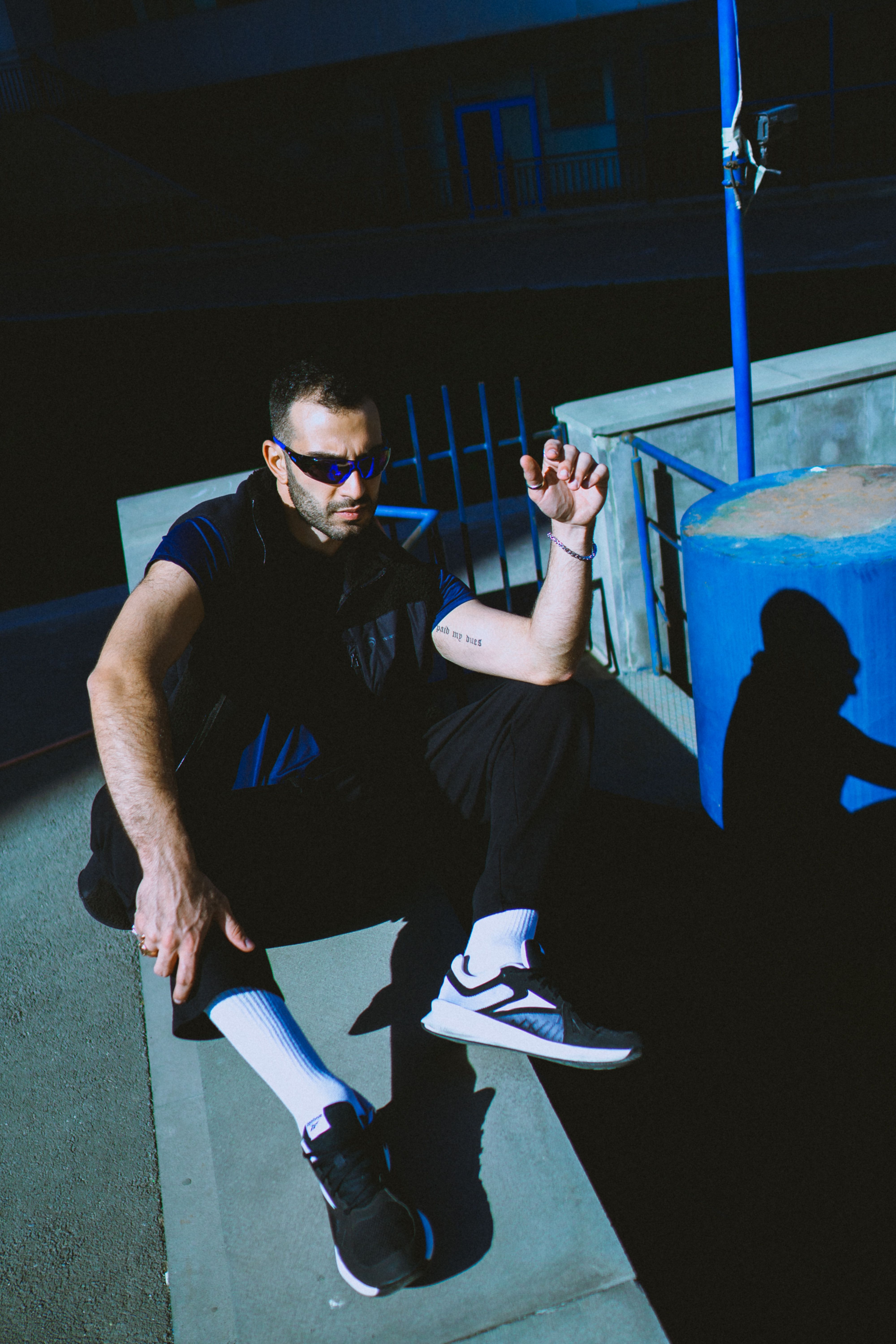 Stylish man in sunglasses posing outdoors in Yerevan, Armenia. Captivating urban fashion shot.