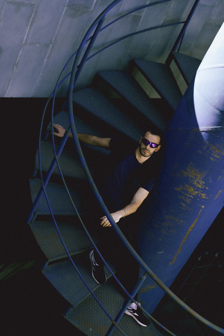 A Man With Sunglasses Sitting On A Staircase