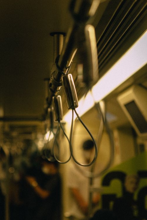 Free A blurred view of a train interior focusing on handles and dim lighting, creating a moody atmosphere. Stock Photo