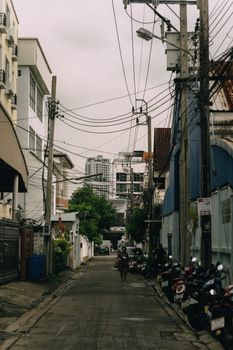 City street view with motorcycles, buildings, and utility poles on an overcast day.