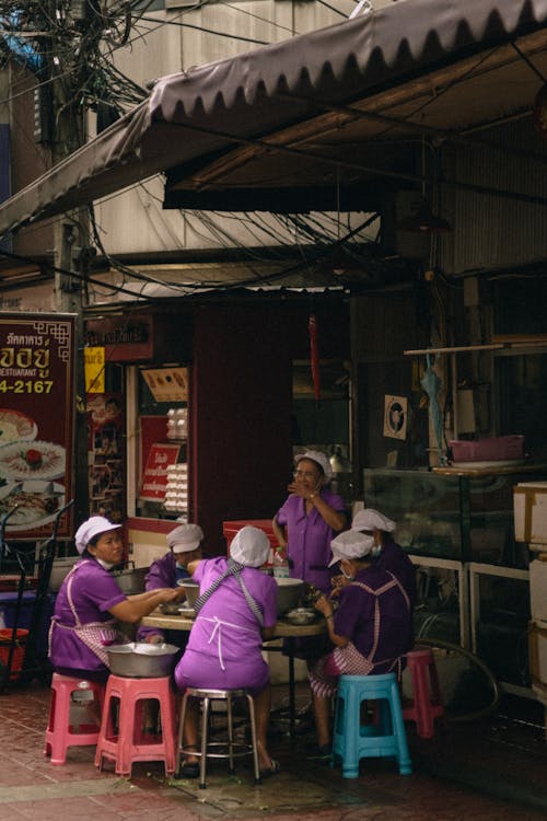 Smiling Women in Uniform Eating on Street Market