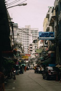 A bustling urban street scene with skyscrapers, vehicles, and pedestrians on a cloudy day.