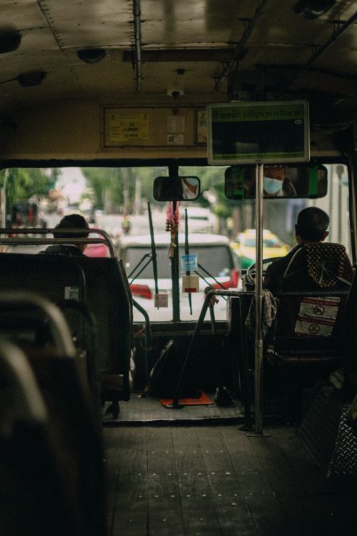 Free Interior view of a public bus during commute with passengers on a cloudy day. Stock Photo