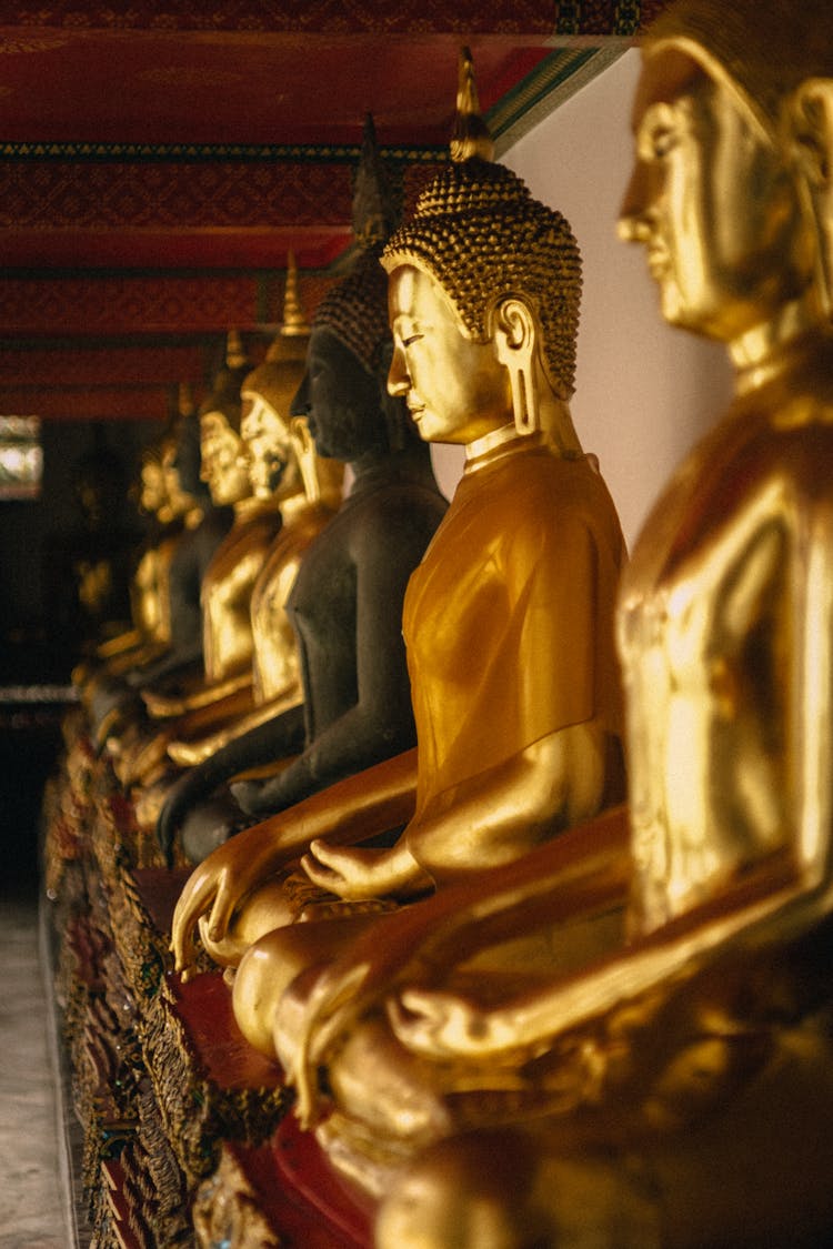 A Row Of Buddha Statues In A Temple 