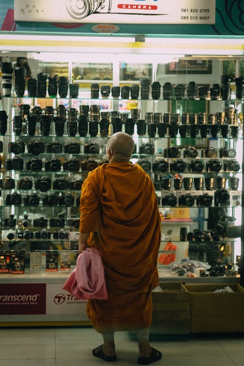 A Monk Looking at Displayed Camera Lenses