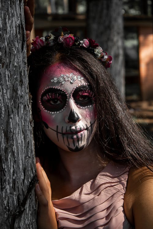 Woman Wearing a Purple Dress with Floral Headdress and Skull Makeup