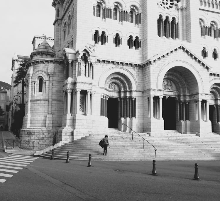 Grayscale Photo Of Person Standing In Front Of Saint Nicholas Cathedral In Monaco