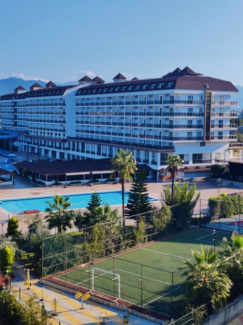 Free Aerial view of a modern resort in Alanya, Turkey, featuring a swimming pool and tennis court. Stock Photo