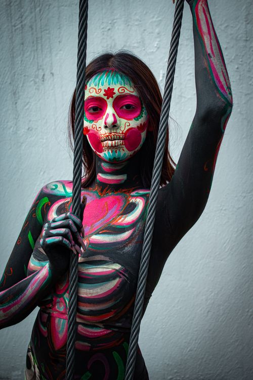 Free Vibrant Day of the Dead inspired body painting with intricate face designs and patterns. Stock Photo