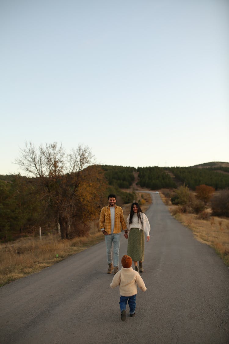 Photo Of A Family Walking On A Road