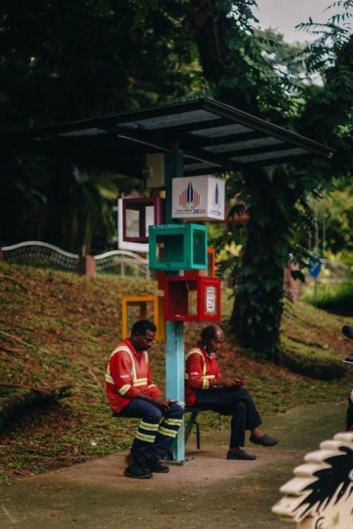 Men Using Smartphones at Bus Stop