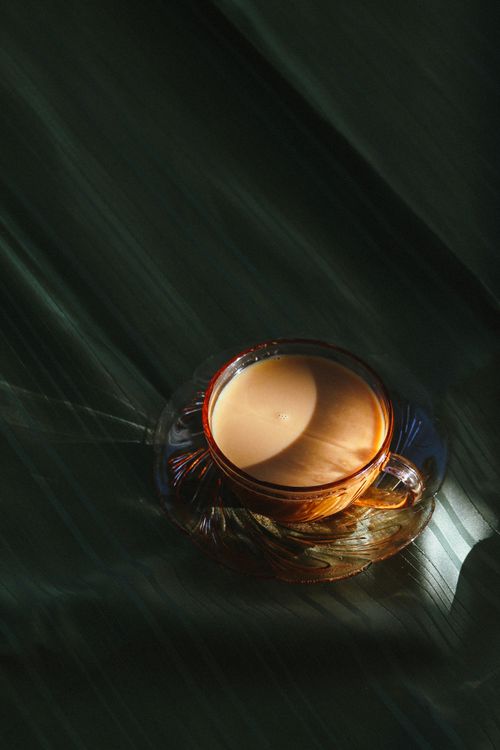 Free Elegant glass cup of coffee casting shadows on a textured surface, captured from above. Stock Photo