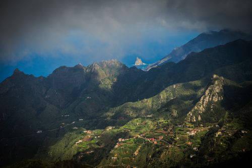 Free Breathtaking view of rolling mountains and deep blue sea under dramatic clouds. Stock Photo