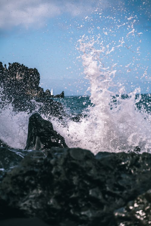 Close-Up Photo of Water Splash Near a Rock