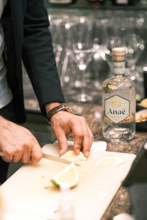 Free A person slicing lime with a knife on a chopping board at a Paris bar. Stock Photo