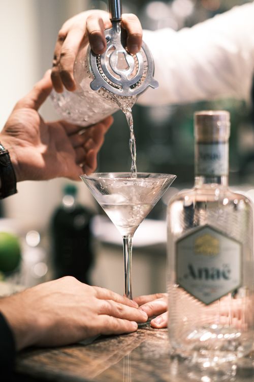 Free Close-up of gin being poured into a martini glass in a Paris bar setting. Stock Photo