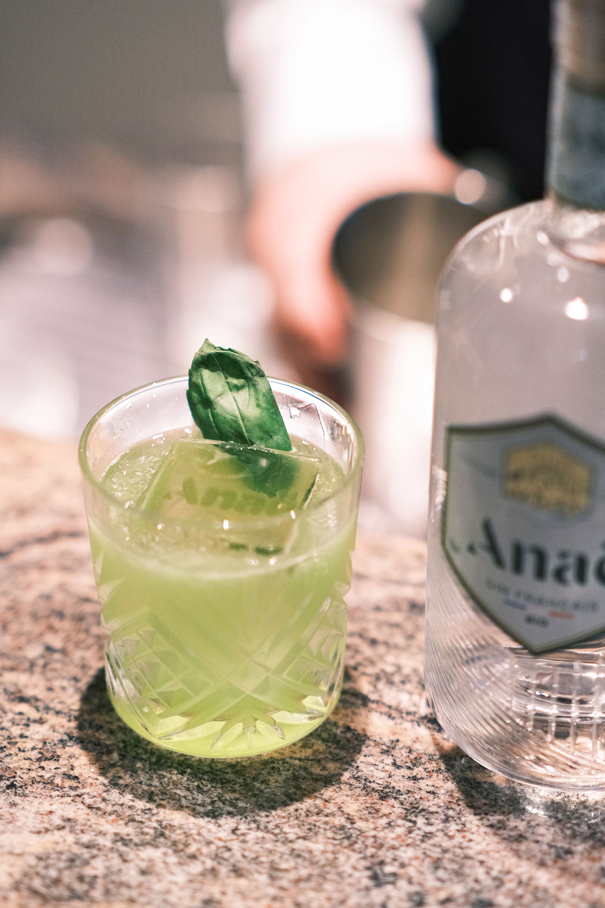 Close-up of a green cocktail with basil leaf garnish, perfect for a refreshing drink experience in Paris.