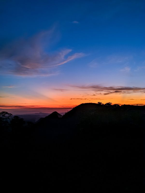 Linda silhueta de pôr do sol sobre montanhas em Alto Rio Novo, Brasil.