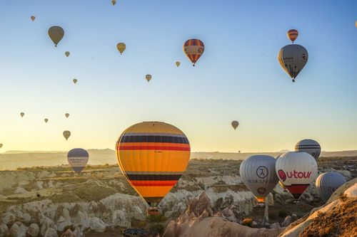 Free Hot air balloons soar over Cappadocia's stunning landscape at sunrise, offering a breathtaking view. Stock Photo