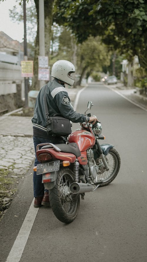 A Man Pushing a Motorcycle 