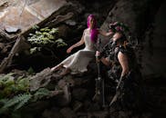 在一处后世界末日的废墟中，一名白衣女子与一名身着科幻装甲的人物并肩而立