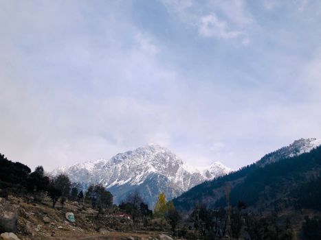 Captivating view of snow-capped mountains with a cloudy sky backdrop, perfect for nature lovers.