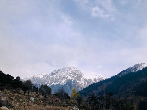 Free Captivating view of snow-capped mountains with a cloudy sky backdrop, perfect for nature lovers. Stock Photo