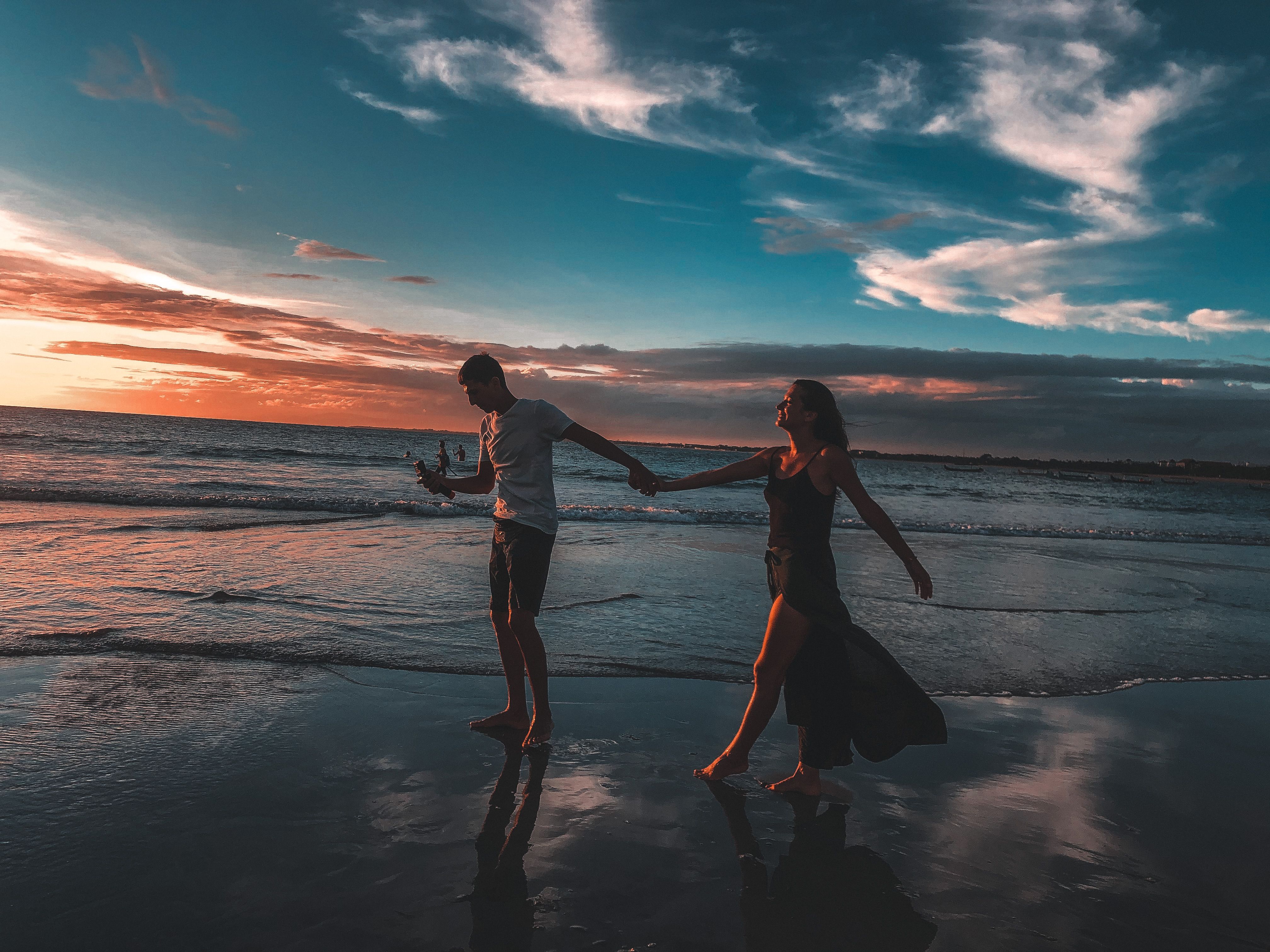 Couple Walking on Beach During Sunset · Free Stock Photo