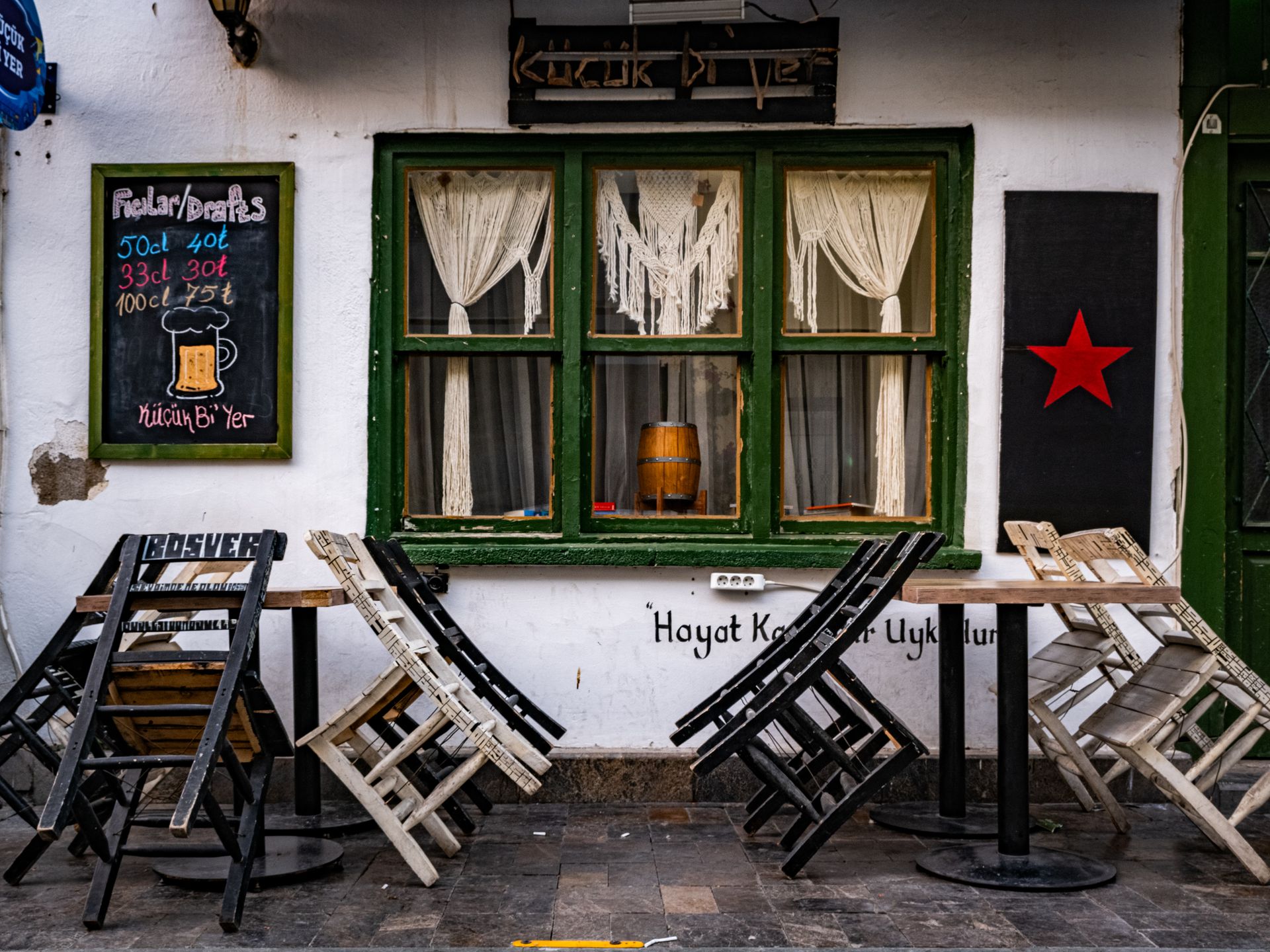 Charming outdoor bar with wooden chairs and vintage decor, perfect for a relaxed hangout.