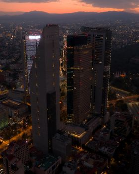 Stunning aerial view of Torre Reforma and neighboring skyscrapers at sunset in Mexico City.