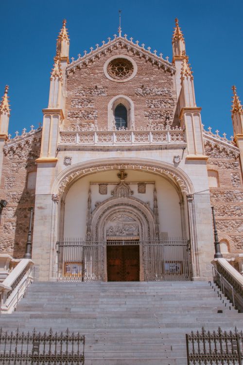 Free Intricate Gothic facade of a historic cathedral in Madrid under a clear blue sky. Stock Photo