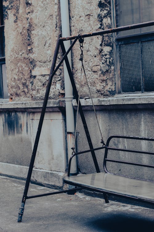 Black Metal Swing Near Gray Concrete Wall